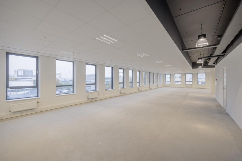 Spacious, empty office space with large windows and modern ceiling lighting on Hiridostraat.